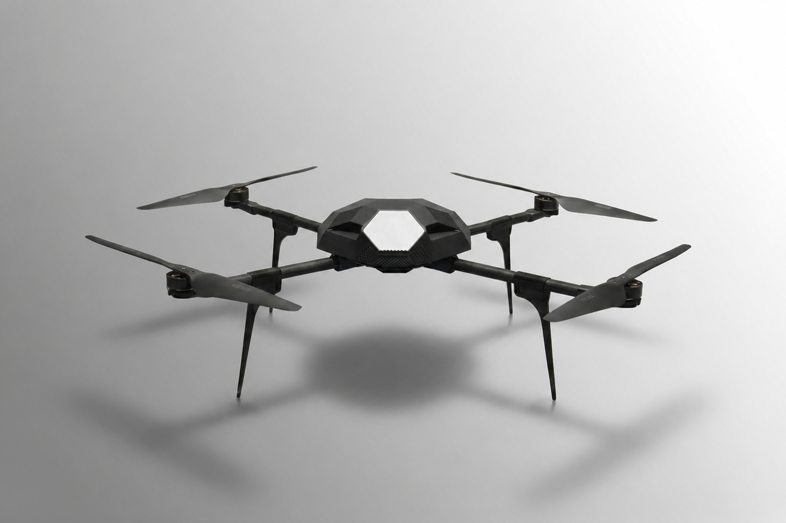Front view of a black quadcopter airframe in a studio setting.